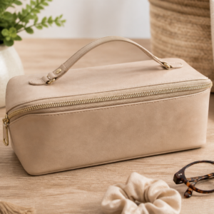 Neutral faux leather Zip N Grip cosmetic bag styled on a vanity with makeup brushes and beauty essentials.