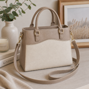 Neutral faux leather Regan handbag styled in a warm modern lifestyle setting with gold hardware and structured silhouette.