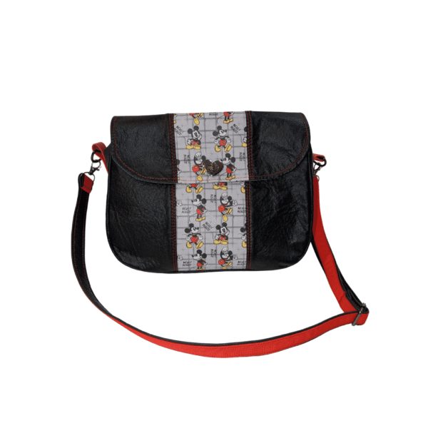 Black printed crossbody handbag with red accents and adjustable strap