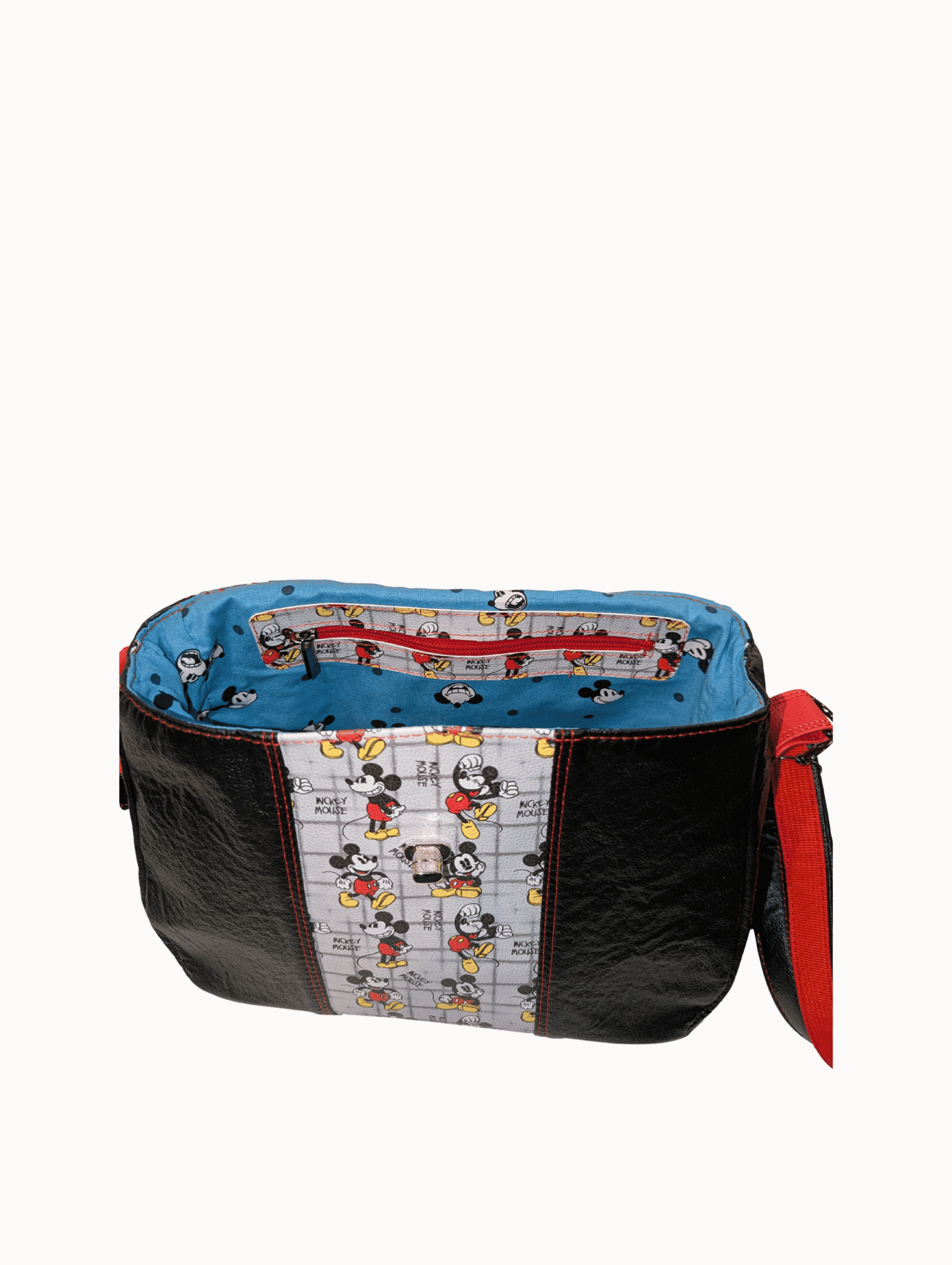 Open crossbody handbag showing blue printed lining and interior zipper pocket