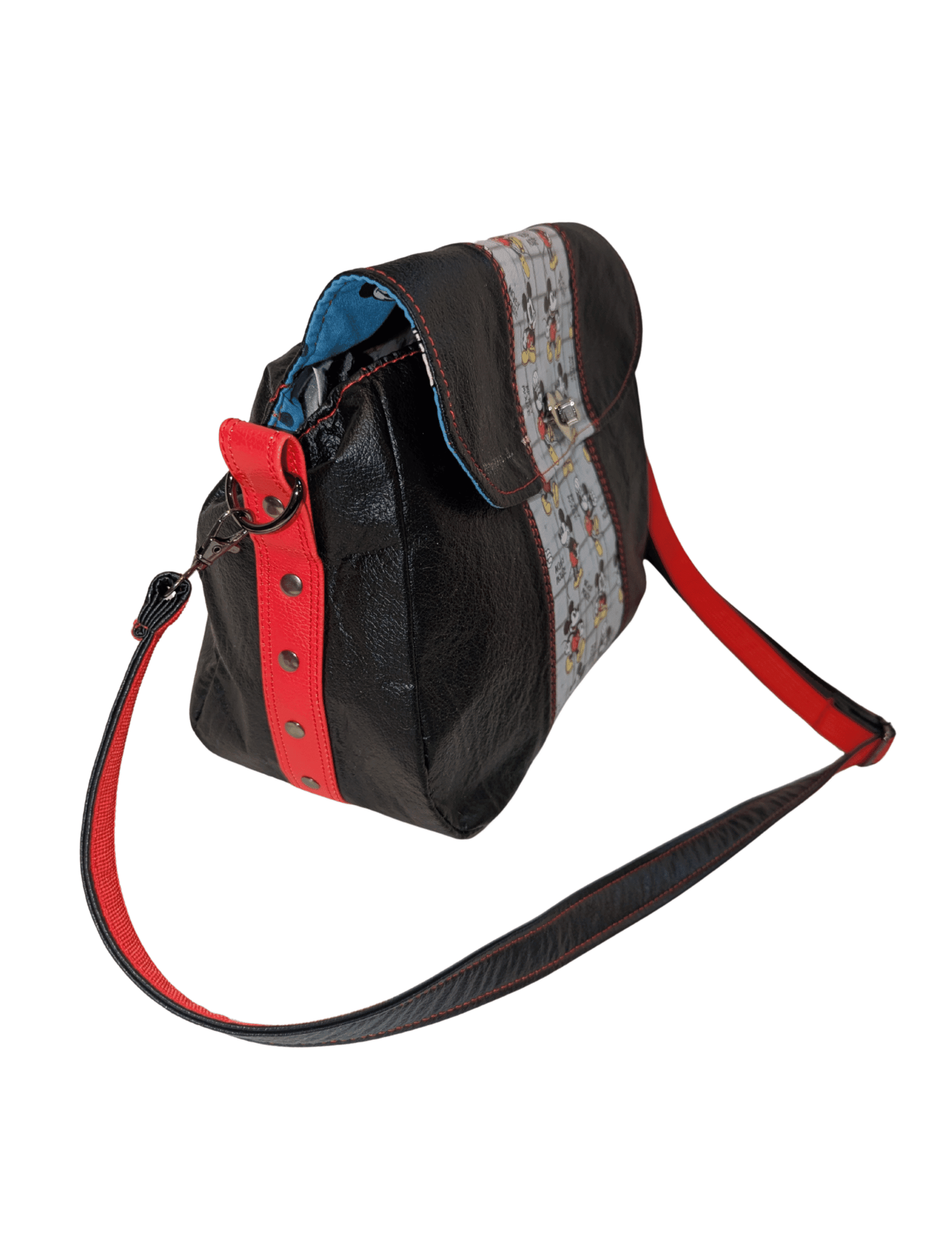 Side view of black crossbody handbag with red riveted strap detail