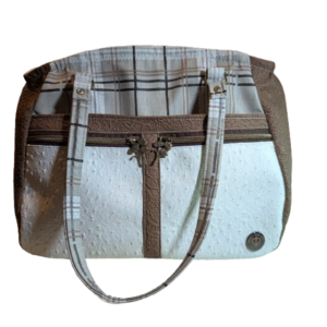 Front view of neutral Girasol handbag with faux leather accents and organized zipper pockets.
