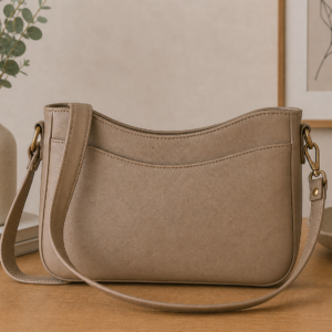 Neutral faux leather Kiana crossbody bag with curved top edge and minimalist everyday styling.