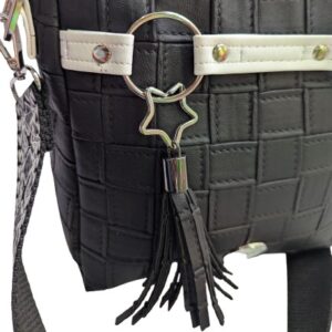 Close-up of a handmade black faux leather crossbody handbag featuring a removable black tassel with a star-shaped keyring charm and premium silver hardware.