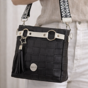 black faux leather crossbody handbag worn on model adjustable strap