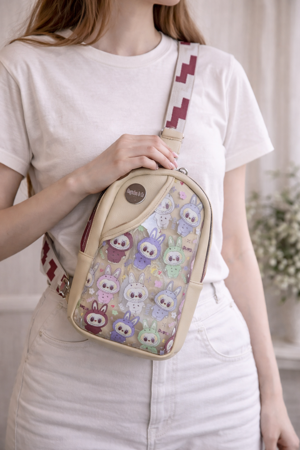 beige character sling bag crossbody purse worn on model front view