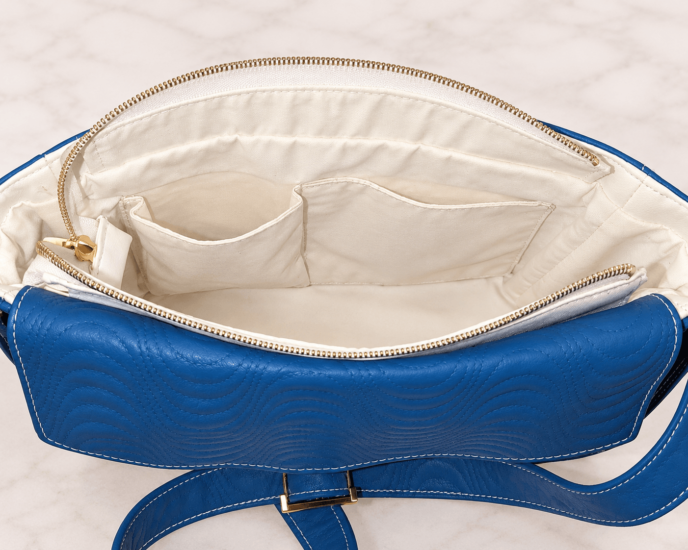 White lined blue crossbody bag interior with divided slip pockets