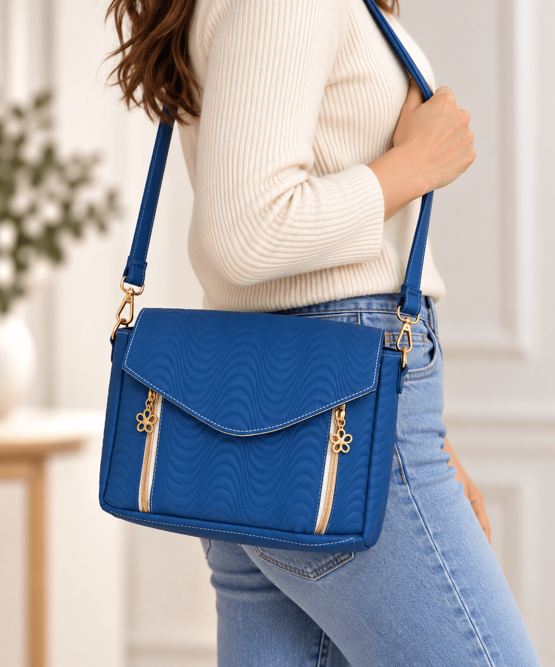 Model wearing blue quilted crossbody bag with adjustable strap