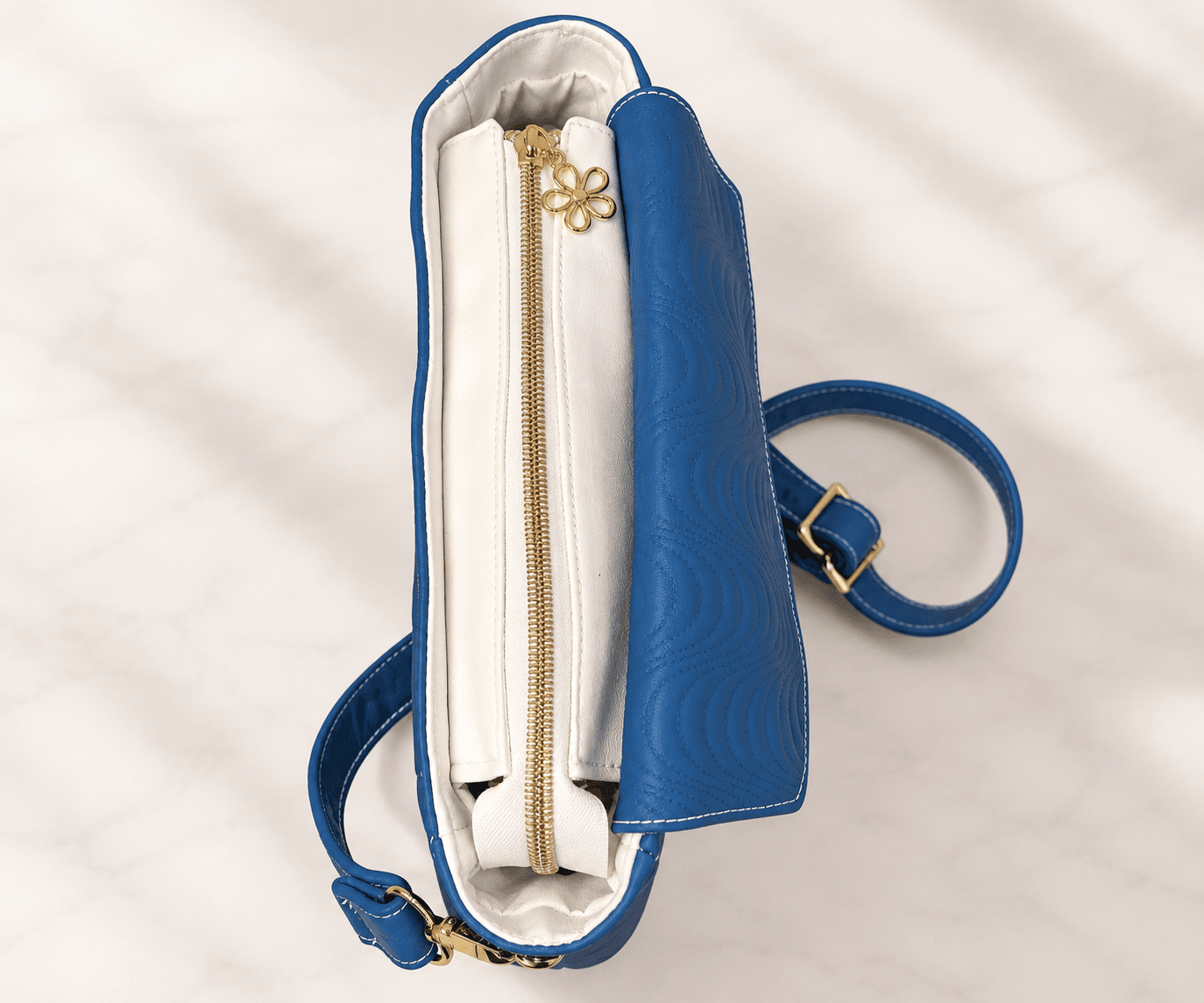 Top view of blue crossbody bag showing zippered main compartment