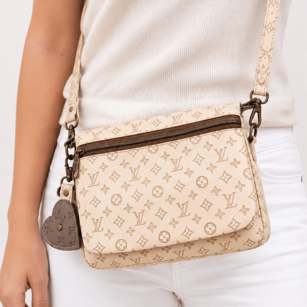 Cream monogram crossbody wallet worn with a white outfit showing the bag's size and crossbody fit