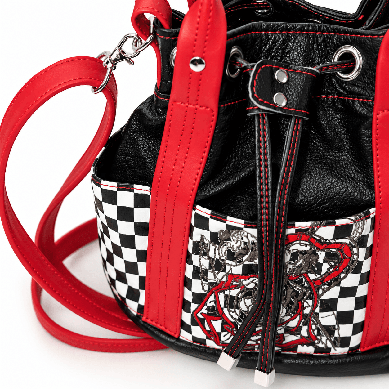 Close-up of black drawstring closure, red stitching and checkerboard detail on bucket handbag