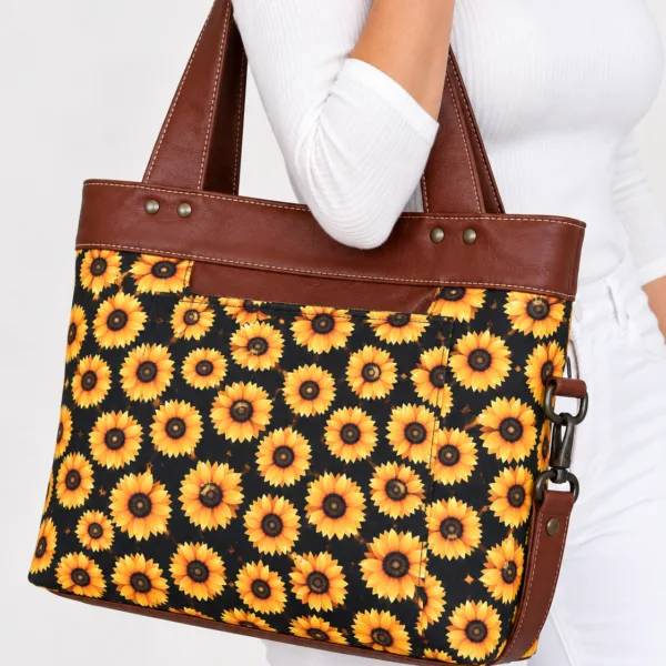Model wearing a handmade sunflower tote bag with brown trim and handles