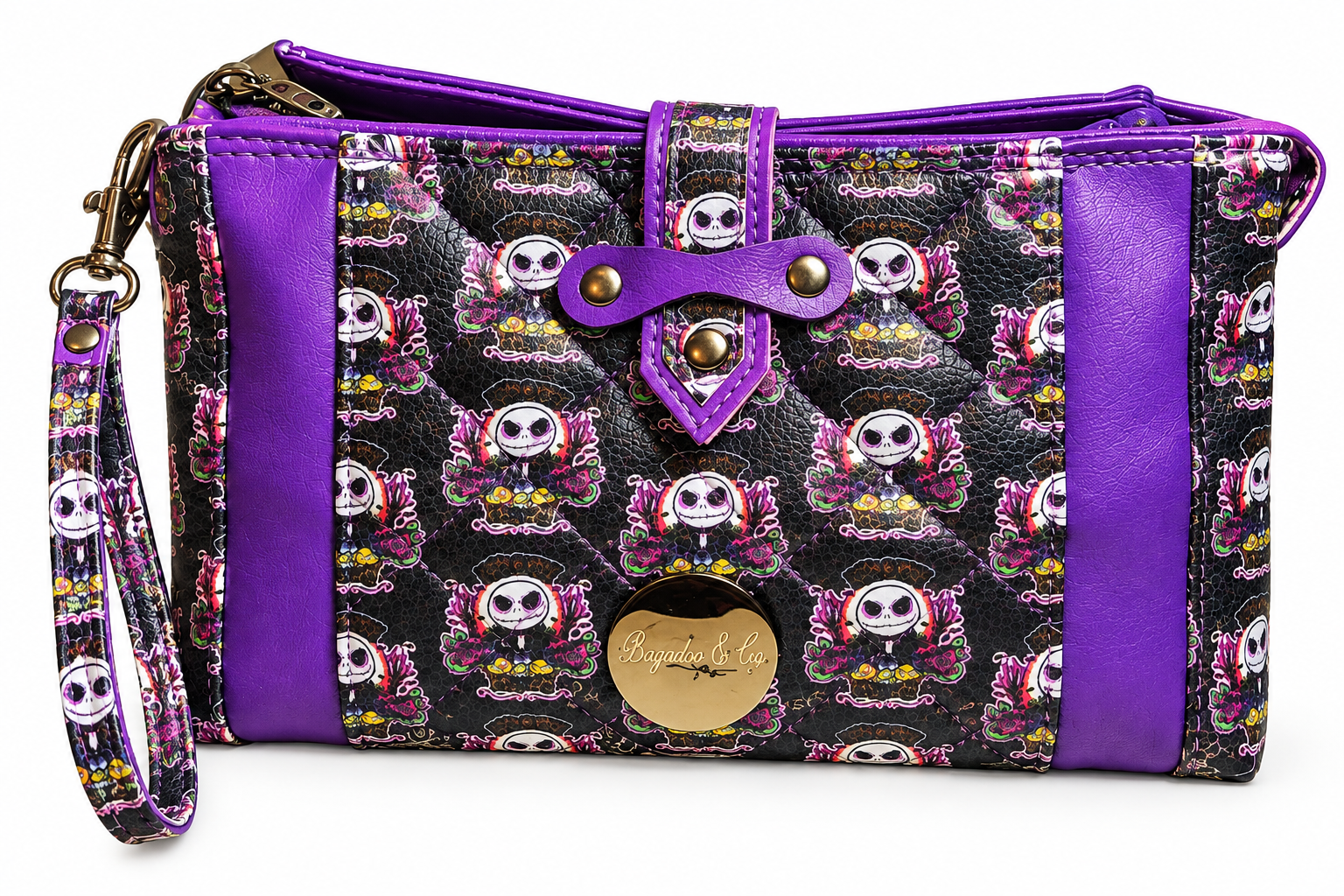 Handmade purple and black skull-print wristlet with quilted exterior, purple faux leather accents, decorative riveted strap, and matching wrist strap.