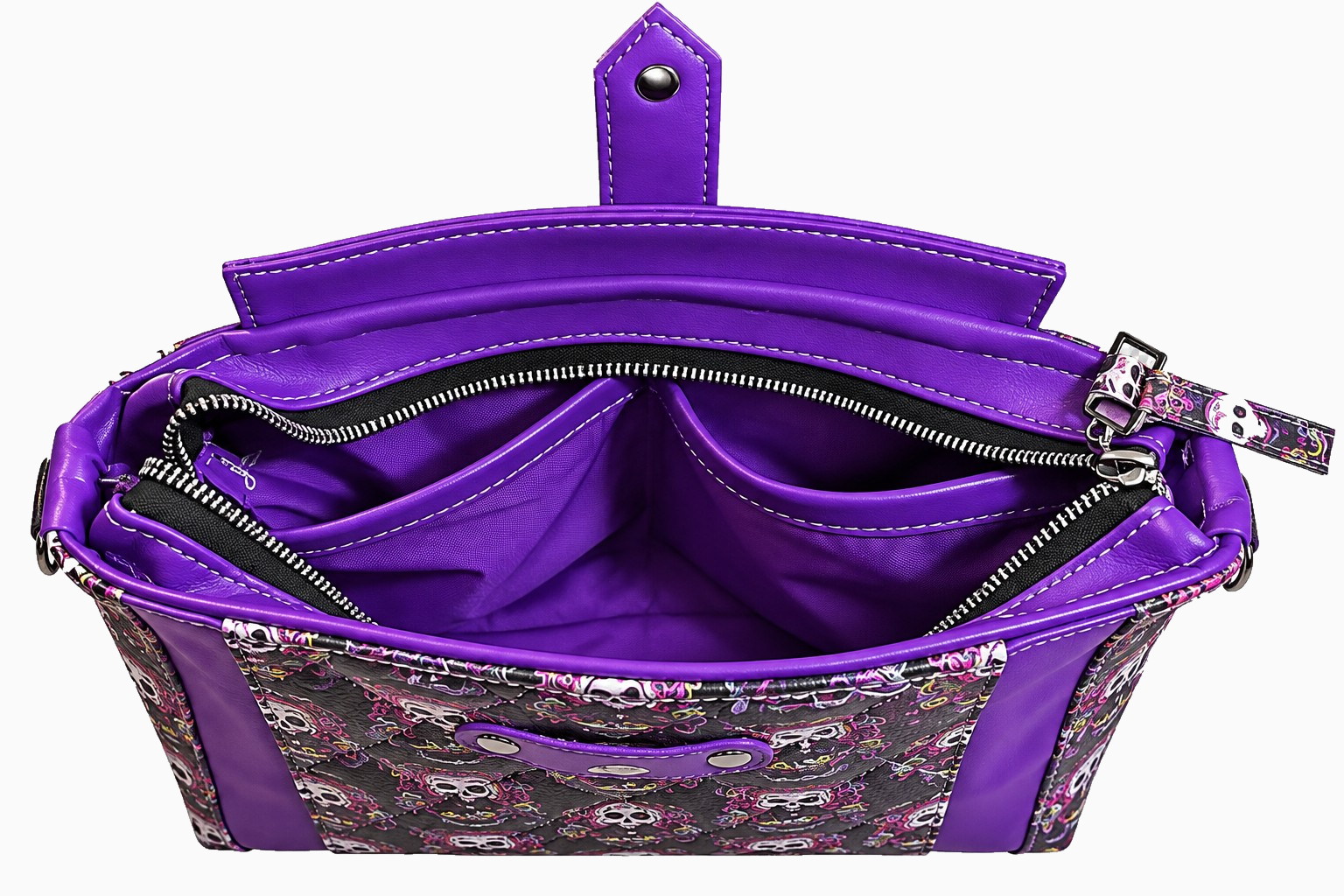 Open purple and black skull-print wristlet showing purple lining, interior slip pockets, and zippered opening.